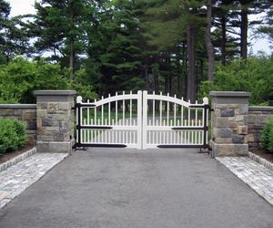 White wooden entry gate with black strap hinges by Tri State Gate, New York