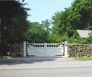 Updated farmhouse design wooden driveway gate by Tri State Gate, New York