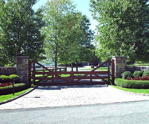 Modern ranch-style wooden driveway gate design by Tri State Gate, New York