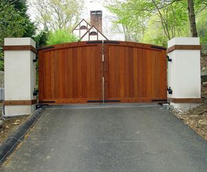 Cedar wood driveway gate with iron stud detail by Tri State Gate, New York