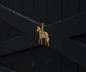 Metal horse-and-rider cut-out detail