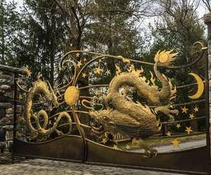 Custom-designed driveway gates with mythological creatures and sun, moon, and star details