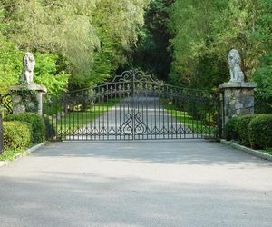 Classic style wrought-iron driveway entrance gate with custom lion statues. Designed and installed by Tri State Gate, Bedford Hills, New York.