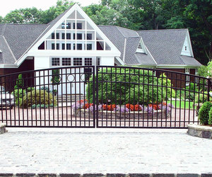 This residential iron driveway gate has a modern design with simple details – by Tri State Gate, New York