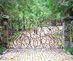 Highly stylized wrought-iron gate design with leaf, vine, and custom wording details by Tri State Gate, New York