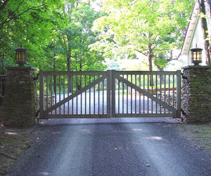 A simple weathered wood automated driveway gate by Tri State Gate, New York