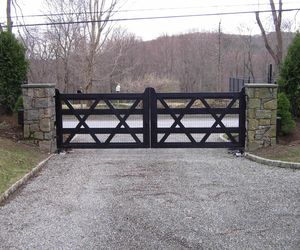 Wood driveway gate painted black with welded wire fencing added, by Tri State Gate, New York
