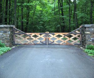 Weathered cedar wood gate with metal hinges detail by Tri State Gate, New York