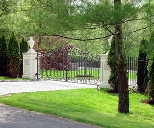 Traditional design wrought-iron gate with custom statuary on concrete pillars. Designed and installed by Tri State Gate, New York.