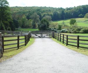 Automated wood gate with post-and-rail fencing on a farm property by Tri State Gate, New York