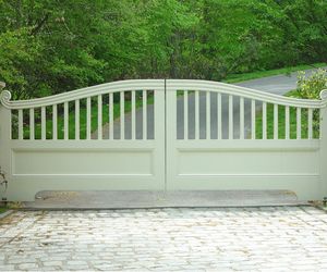 Traditional wooden driveway gate with custom scroll detail by Tri State Gate, New York